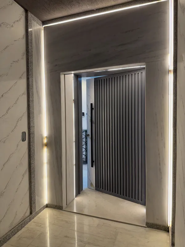 Porte d'entrée en marbre éclairée par des lignes de lumière